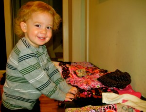 Nash smiles with a pile of new clothes for Baby Opi! It's going to be so much fun to dress a little girl! 