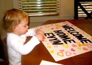 making a sign to welcome home baby sister